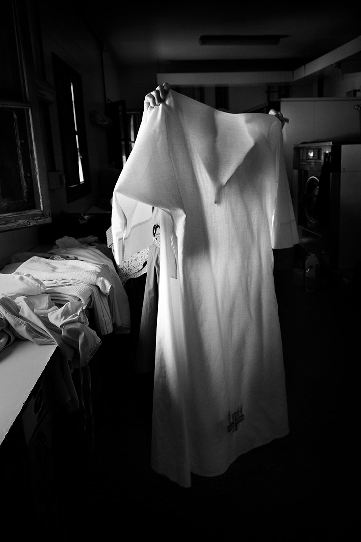 White clothing hanging in a dark interior.